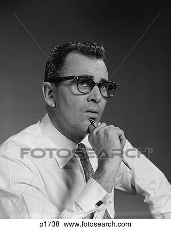 Stock Photo - 1960S Man Thinking Hand Pencil On Chin Wearing Eyeglasses Serious Expression. Fotosearch