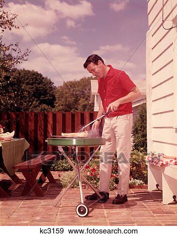 1960S Man Wearing Red Shirt Cooking Steak Outdoor On Backyard Grill View Large Photo Image Stock Photo - 1960S Man Wearing Red Shirt Cooking Steak Outdoor On Backyard Grill . Fotosearch