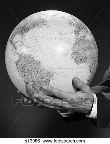 Stock Photograph - 1960S Mans Hand Holding Globe Of The World. Fotosearch