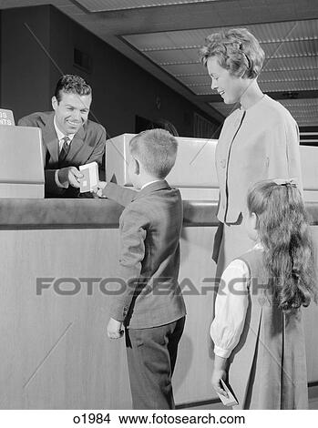 1960S Mother Two Children Boy Handing Banking Deposit To Male Bank Teller View Large Photo Image Picture - 1960S Mother Two Children Boy Handing Banking Deposit To Male Bank Teller. Fotosearch