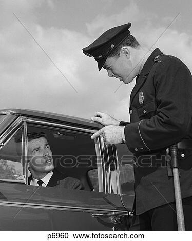 Stock Image - 1960S Police Officer Warning Motorist Pointing Finger At Driver . Fotosearch