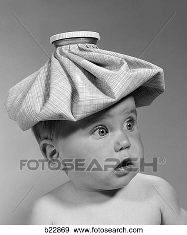 Stock Photo - 1960S Portrait Baby Wide-Eyed With Mouth Open & Ice Pack On Head Looking Off To Side. Fotosearch