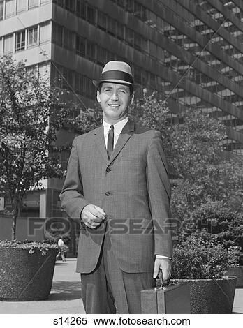Stock Photography - 1960S Portrait Businessman Wearing Hat Suit Holding Briefcase. Fotosearch