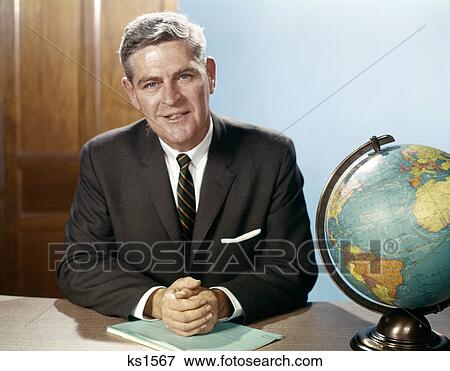 1960S Portrait Man Businessman Sitting At Desk Next To Globe Of The Earth View Large Photo Image Stock Photo - 1960S Portrait Man Businessman Sitting At Desk Next To Globe Of The Earth . Fotosearch