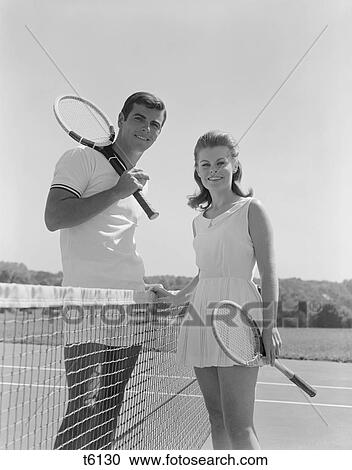 1960S Portrait Tennis Couple Man Woman Holding Racquets Standing By Net View Large Photo Image Stock Image - 1960S Portrait Tennis Couple Man Woman Holding Racquets Standing By Net . Fotosearch