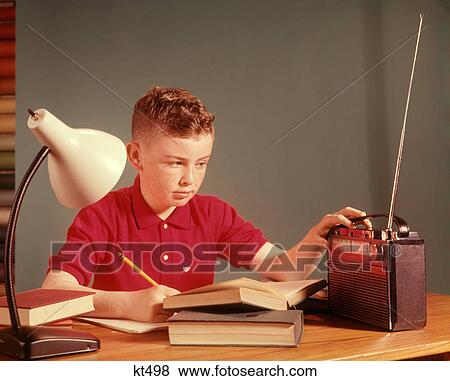 1960S Red Hair Boy Sitting At Deslistening To Portable Radio While Studying Homework View Large Photo Image Stock Photo - 1960S Red Hair Boy Sitting At Deslistening To Portable Radio While Studying Homework . Fotosearch