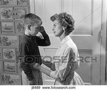 Stock Photo - 1960S Sad Crying Boy Rubbing His Eyes Is Comforted Or Disciplined By His Caring Mother. Fotosearch