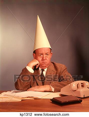 1960S Sad Depressed Businessman Wearing Dunce Cap View Large Photo Image Stock Image - 1960S Sad Depressed Businessman Wearing Dunce Cap. Fotosearch