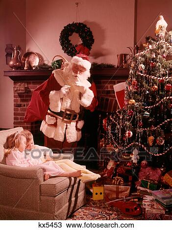 1960S Santa Looking Down On Two Children Boy Girl Asleep In Chair By Fireplace Christmas Tree View Large Photo Image Stock Image - 1960S Santa Looking Down On Two Children Boy Girl Asleep In Chair By Fireplace Christmas Tree. Fotosearch
