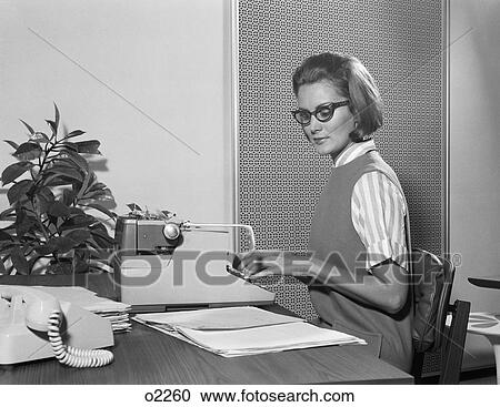 1960S Secretary Typist Wearing Stylish Eyeglasses Using Manual Typewriter At Desk View Large Photo Image Stock Image - 1960S Secretary Typist Wearing Stylish Eyeglasses Using Manual Typewriter At Desk. Fotosearch