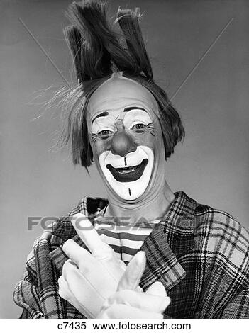 Stock Photography - 1960S Smiling Clown With White Gloved Crossed Hands And Hair Standing On End Looking At Camera. Fotosearch