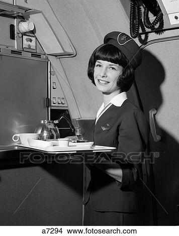 Picture - 1960S Smiling Flight Attendant Holding Tray With Coffee Service Items. Fotosearch