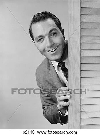 Stock Image - 1960S Smiling Man Business Suit Peeking From Behind Louvered Door. Fotosearch