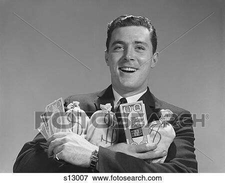 Stock Photo - 1960S Smiling Man Holding Money Bags And Bundles Of Cash. Fotosearch