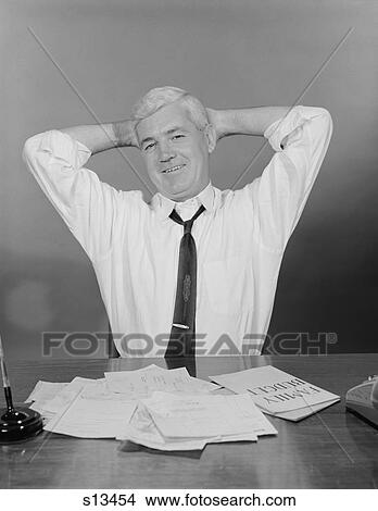 1960S Smiling Man Working On Family Budget Papers At Desk View Large Photo Image Picture - 1960S Smiling Man Working On Family Budget Papers At Desk. Fotosearch