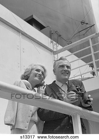 1960S Smiling Mature Couple At Shipboard Rail With Binoculars View Large Photo Image Stock Photo - 1960S Smiling Mature Couple At Shipboard Rail With Binoculars. Fotosearch