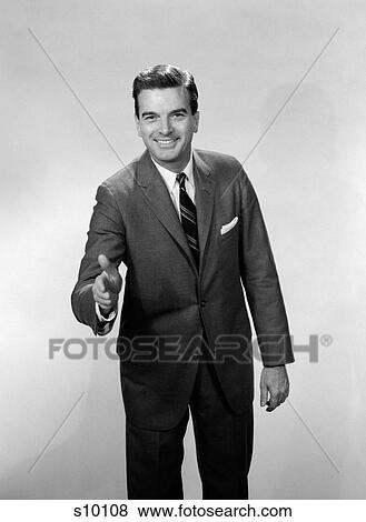 1960S Smiling Salesman Or Businessman Leaning Forward Extending Hand For Handshake View Large Photo Image Stock Photo - 1960S Smiling Salesman Or Businessman Leaning Forward Extending Hand For Handshake. Fotosearch