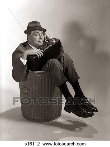 1960S Symbolic Businessman In Suit And Hat Holding Briefcase Dumped Fired Made Redundant Laid Off Unemployed Sitting In Trash Can View Large Photo Image Stock Image - 1960S Symbolic Businessman In Suit And Hat Holding Briefcase Dumped Fired Made Redundant Laid Off Unemployed Sitting In Trash Can. Fotosearch