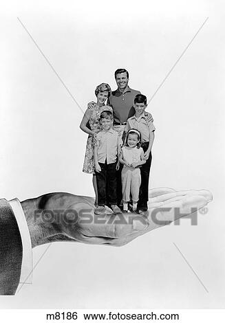 Stock Photograph - 1960S Symbolic Portrait Of Family Father Son Mother Daughter Held Standing Together In Palm Of Hand. Fotosearch
