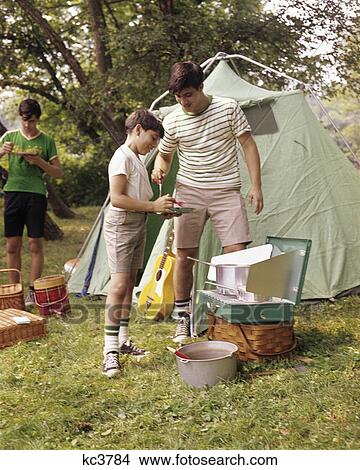 Picture - 1960S Three Boys At Campsite Cooking Camp Stove Eating Food Tent Teens. Fotosearch