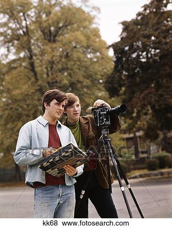 1960S Two Teen Boys One Operating Movie Camera The Other Holding Scene Marker Outdoors View Large Photo Image Stock Photo - 1960S Two Teen Boys One Operating Movie Camera The Other Holding Scene Marker Outdoors. Fotosearch