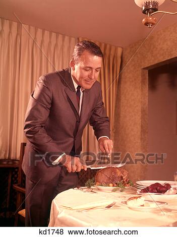 Stock Photo - 1960S Well-Dressed Man Carving Roast Beef At Dinner Table. Fotosearch
