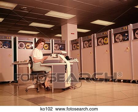 Stock Image - 1960S Woman Data Entry Computer B-5000 Reels Of Magnetic Tape Main Frame Office Work Working Computers . Fotosearch