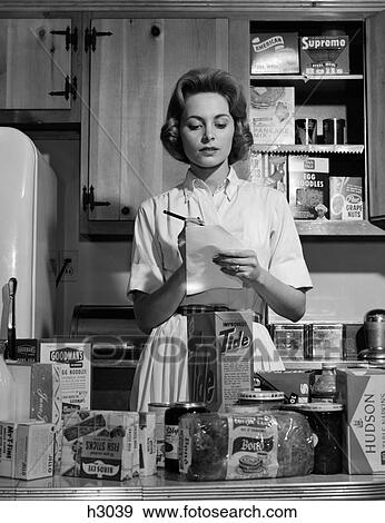 1960S Woman Housewife In Kitchen Checking Grocery Food Shopping List View Large Photo Image Stock Photo - 1960S Woman Housewife In Kitchen Checking Grocery Food Shopping List. Fotosearch