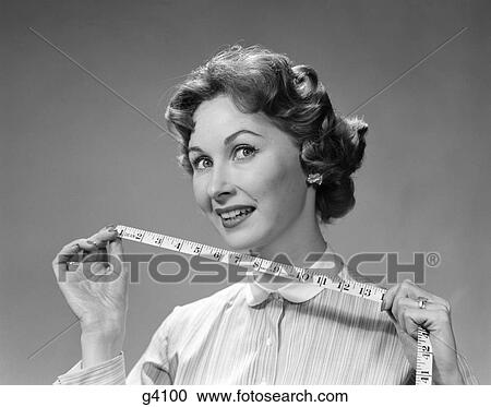 Stock Image - 1960S Woman Portrait Holding Measuring Tape. Fotosearch
