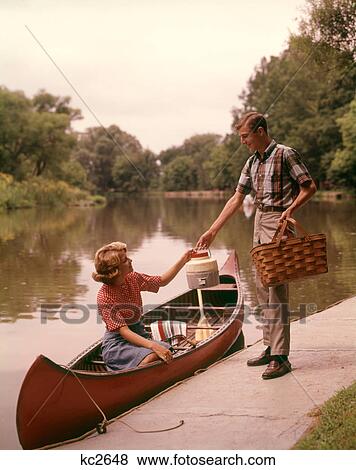 1960S Young Couple Loading Picnic Basket Thermos Into Canoe View Large Photo Image Stock Photo - 1960S Young Couple Loading Picnic Basket Thermos Into Canoe . Fotosearch