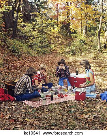 Stock Image - 1970S 1980S Group Teen Boys Girls Having Autumn Picnic. Fotosearch