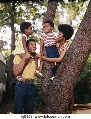 1970S African American Family Mother Father Two Children Outdoor By Tree Trunk View Large Photo Image Stock Photo - 1970S African American Family Mother Father Two Children Outdoor By Tree Trunk. Fotosearch
