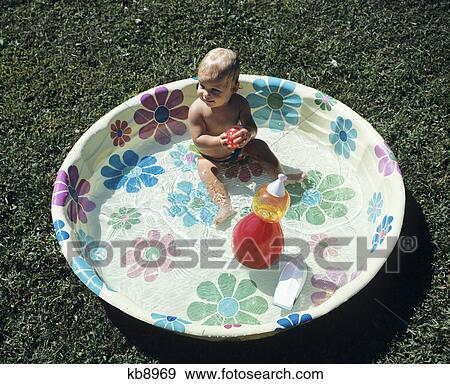 1970S Baby Sitting In Plastic Backyard Kiddy Pool Viewed From Above View Large Photo Image Stock Photo - 1970S Baby Sitting In Plastic Backyard Kiddy Pool Viewed From Above. Fotosearch