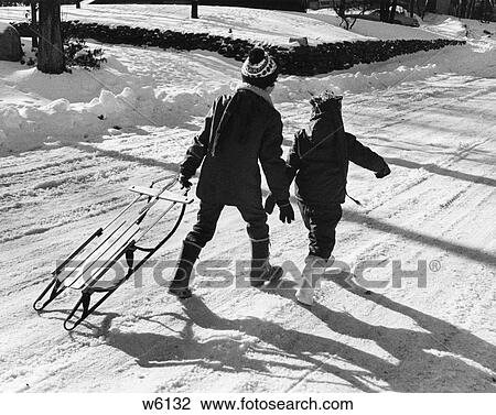 1970S Back View Of Two Children Walking Through Snow Pulling Sled View Large Photo Image Stock Image - 1970S Back View Of Two Children Walking Through Snow Pulling Sled. Fotosearch