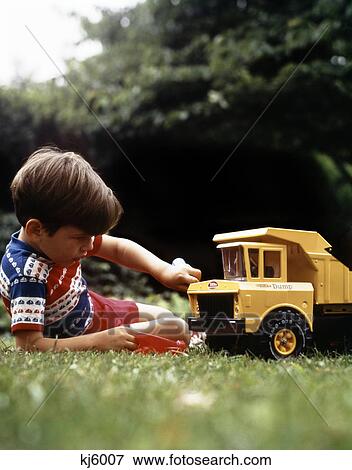 1970S Boy In Grass Playing With Tonka Toy Yellow Dump Truck View Large Photo Image Stock Photo - 1970S Boy In Grass Playing With Tonka Toy Yellow Dump Truck . Fotosearch