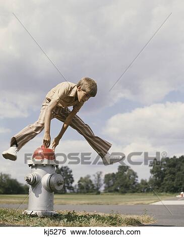 1970S Boy Jumping Over Fire Hydrant View Large Photo Image Stock Photograph - 1970S Boy Jumping Over Fire Hydrant . Fotosearch
