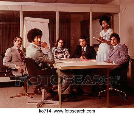 1970S Business Meeting Six Serious People Sitting Around Conference Table View Large Photo Image Picture - 1970S Business Meeting Six Serious People Sitting Around Conference Table. Fotosearch