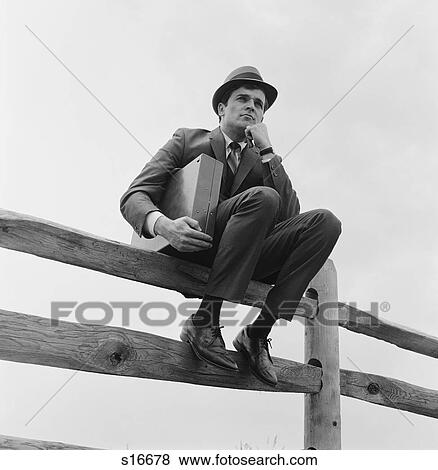 1970S Businessman Sitting On Fence Worried Expression Holding Briefcase View Large Photo Image Stock Photo - 1970S Businessman Sitting On Fence Worried Expression Holding Briefcase. Fotosearch