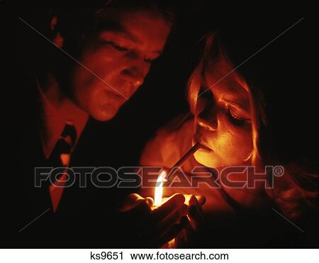 1970S Close-Up Of Couple Man Holding Flame To Light Tobacco Cigarette For Woman View Large Photo Image Stock Image - 1970S Close-Up Of Couple Man Holding Flame To Light Tobacco Cigarette For Woman. Fotosearch