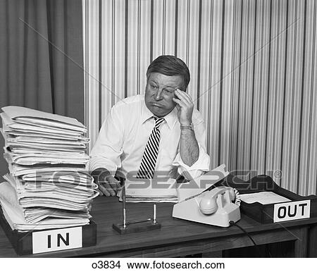 1970S Concerned Businessman Staring Large Pile Paperwork In In-Box View Large Photo Image Picture - 1970S Concerned Businessman Staring Large Pile Paperwork In In-Box . Fotosearch