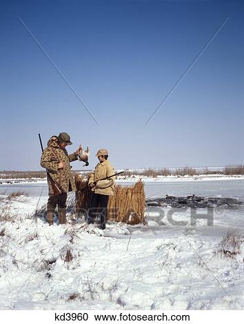 Stock Image - 1970S Father And Son Duck Hunting In Winter Snow Deep Creek, Va. Fotosearch