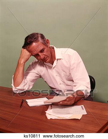 1970S Middle Age Man Sitting At Desk Worried About Bills To Pay View Large Photo Image Stock Image - 1970S Middle Age Man Sitting At Desk Worried About Bills To Pay . Fotosearch