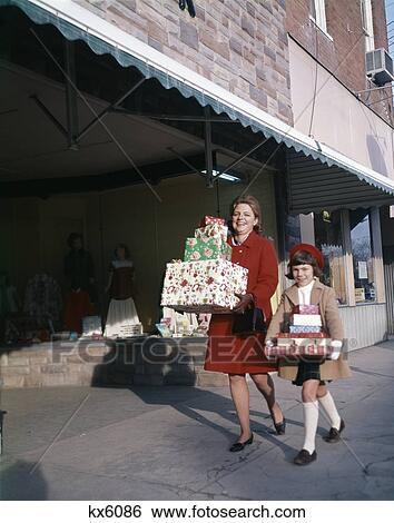 1970S Mother And Daughter Carrying Stacks Of Gift Packages View Large Photo Image Stock Photograph - 1970S Mother And Daughter Carrying Stacks Of Gift Packages. Fotosearch