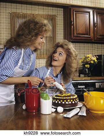 1970S Mother Daughter Dressed Alike Decorating Cake View Large Photo Image Stock Photo - 1970S Mother Daughter Dressed Alike Decorating Cake . Fotosearch