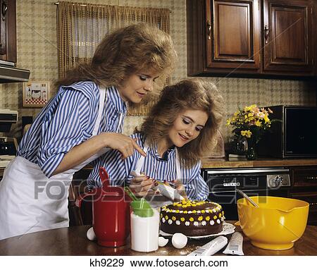 1970S Mother Daughter Dressed Alike Decorating Cake View Large Photo Image Stock Photo - 1970S Mother Daughter Dressed Alike Decorating Cake . Fotosearch