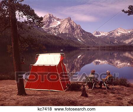 1970S Older Couple Sitting Camping By Red Tent Stanley Lake Idaho View Large Photo Image Stock Photo - 1970S Older Couple Sitting Camping By Red Tent Stanley Lake Idaho . Fotosearch