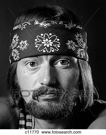 1970S Portrait Male With Long Dark Hair & Beard & Mustache Wearing Gold Chain Striped Tank Top & Bandana Around Head View Large Photo Image Stock Image - 1970S Portrait Male With Long Dark Hair & Beard & Mustache Wearing Gold Chain Striped Tank Top & Bandana Around Head. Fotosearch