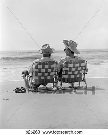 1970S Rear View Of Elderly Couple In Straw Hats Sitting On Beach Chairs On Shore View Large Photo Image Stock Image - 1970S Rear View Of Elderly Couple In Straw Hats Sitting On Beach Chairs On Shore. Fotosearch