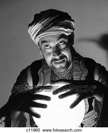 1970S Scary Fortune Teller Man With Hands On Lighted Crystal Ball Wearing Turban View Large Photo Image Stock Image - 1970S Scary Fortune Teller Man With Hands On Lighted Crystal Ball Wearing Turban . Fotosearch