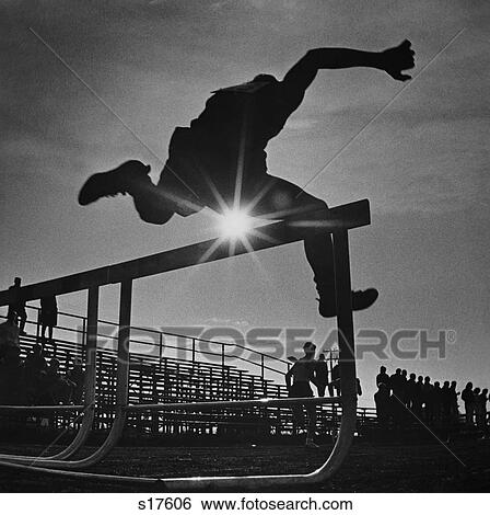 1970S Sun Rays Through Silhouette Of Man Jumping Track Field Hurdle View Large Photo Image Stock Photograph - 1970S Sun Rays Through Silhouette Of Man Jumping Track Field Hurdle. Fotosearch